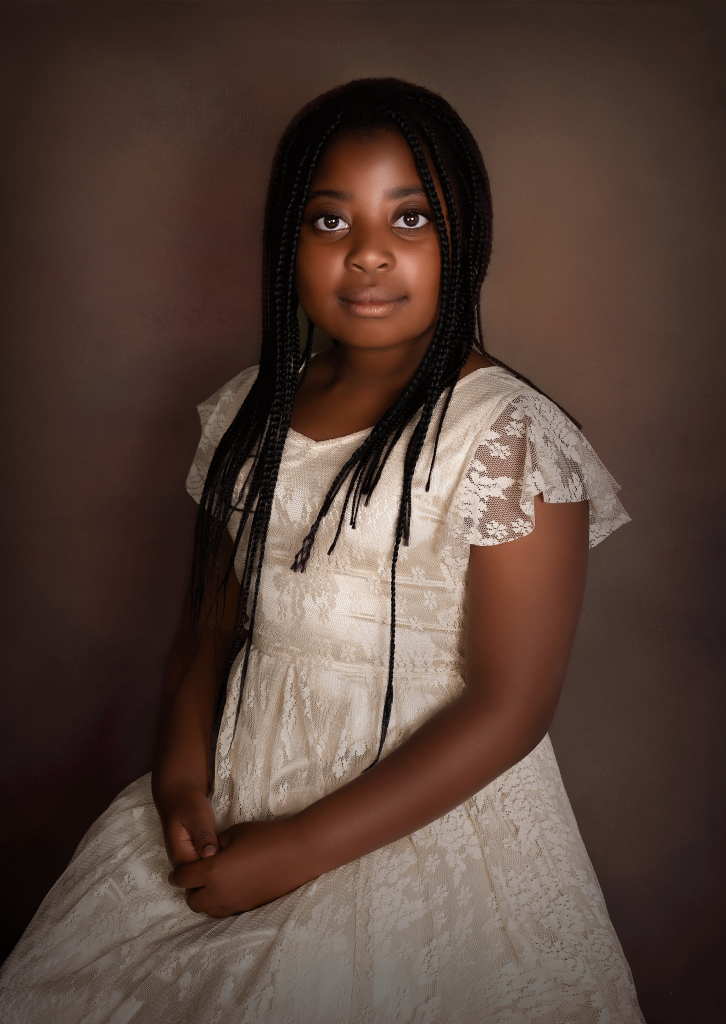 Young girl with long hair in white gown, seated