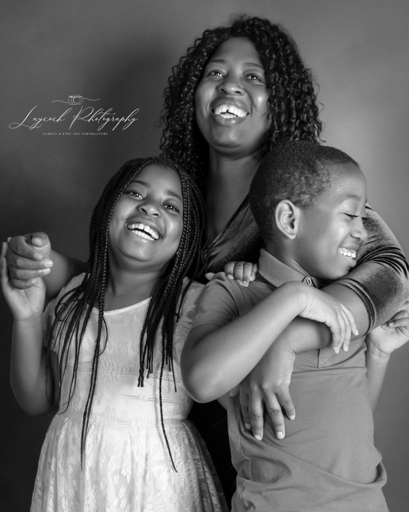 mother with her arm round her son and daughter, laughing